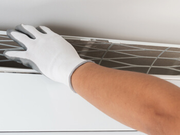 HVAC technician replacing a vent filter